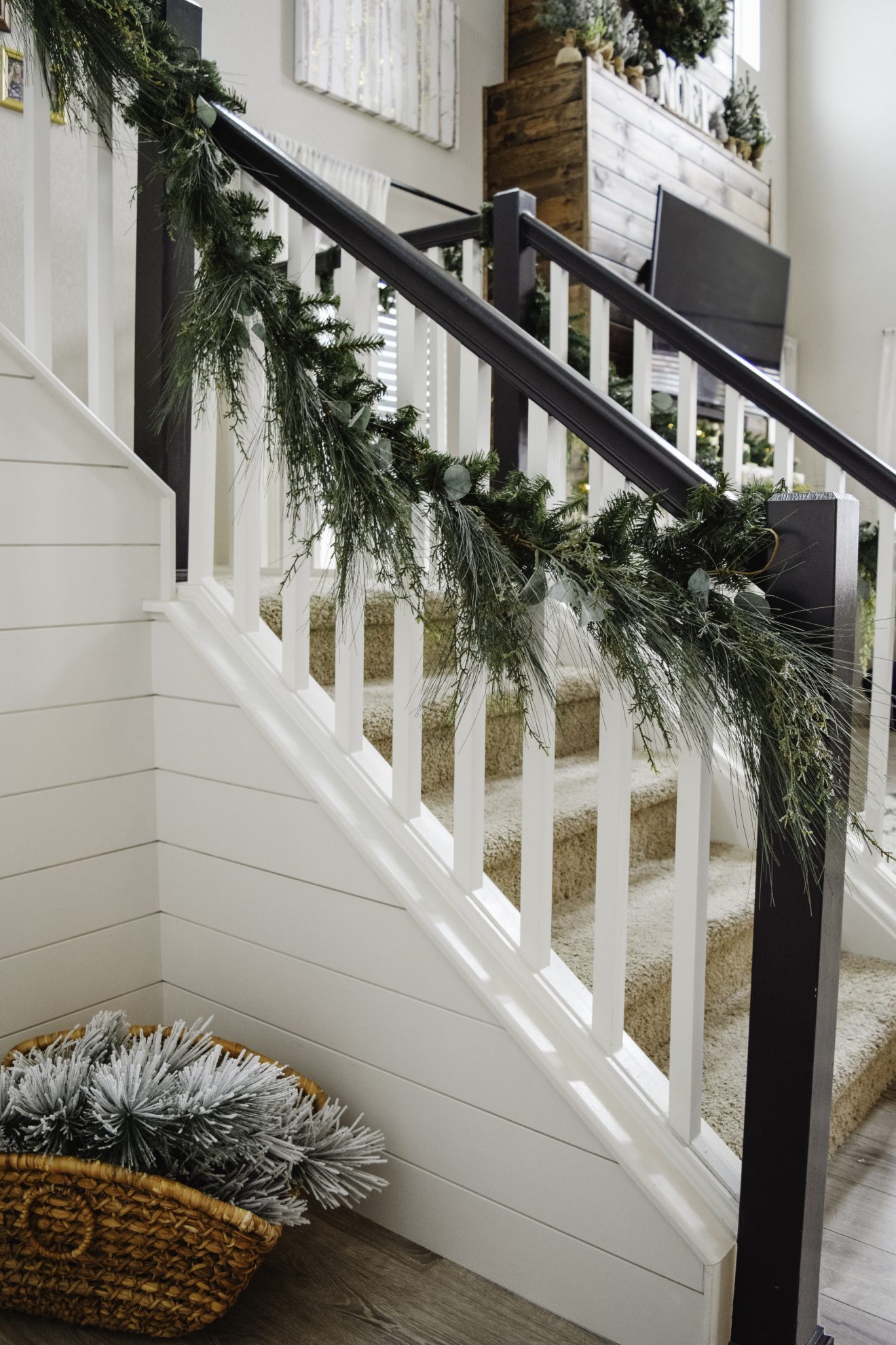 Black and white stair railing with wispy greenery garland