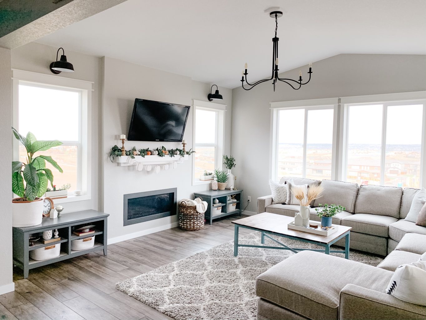 living room with big gray couch and decor and plants.