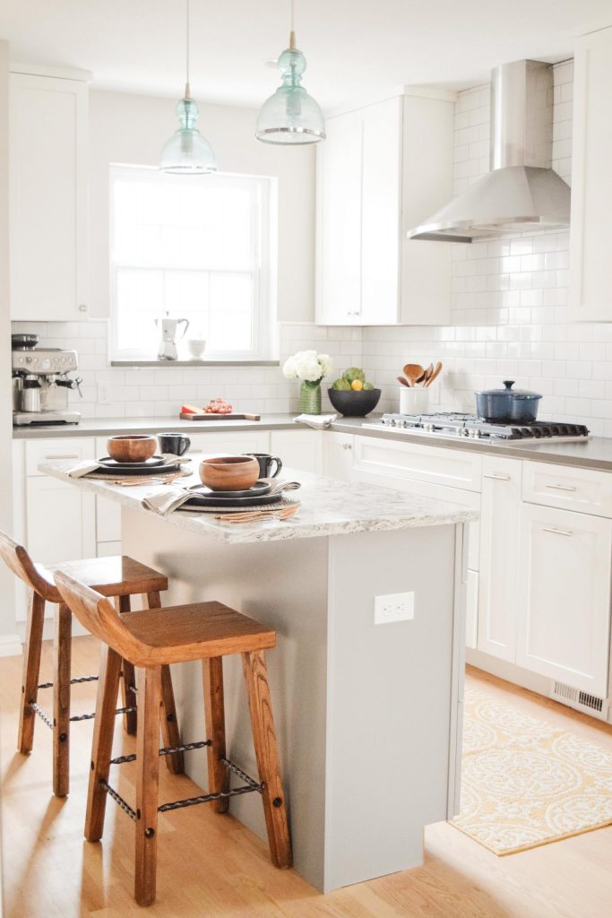 white kitchen cabinets with quartz countertops and granite at island