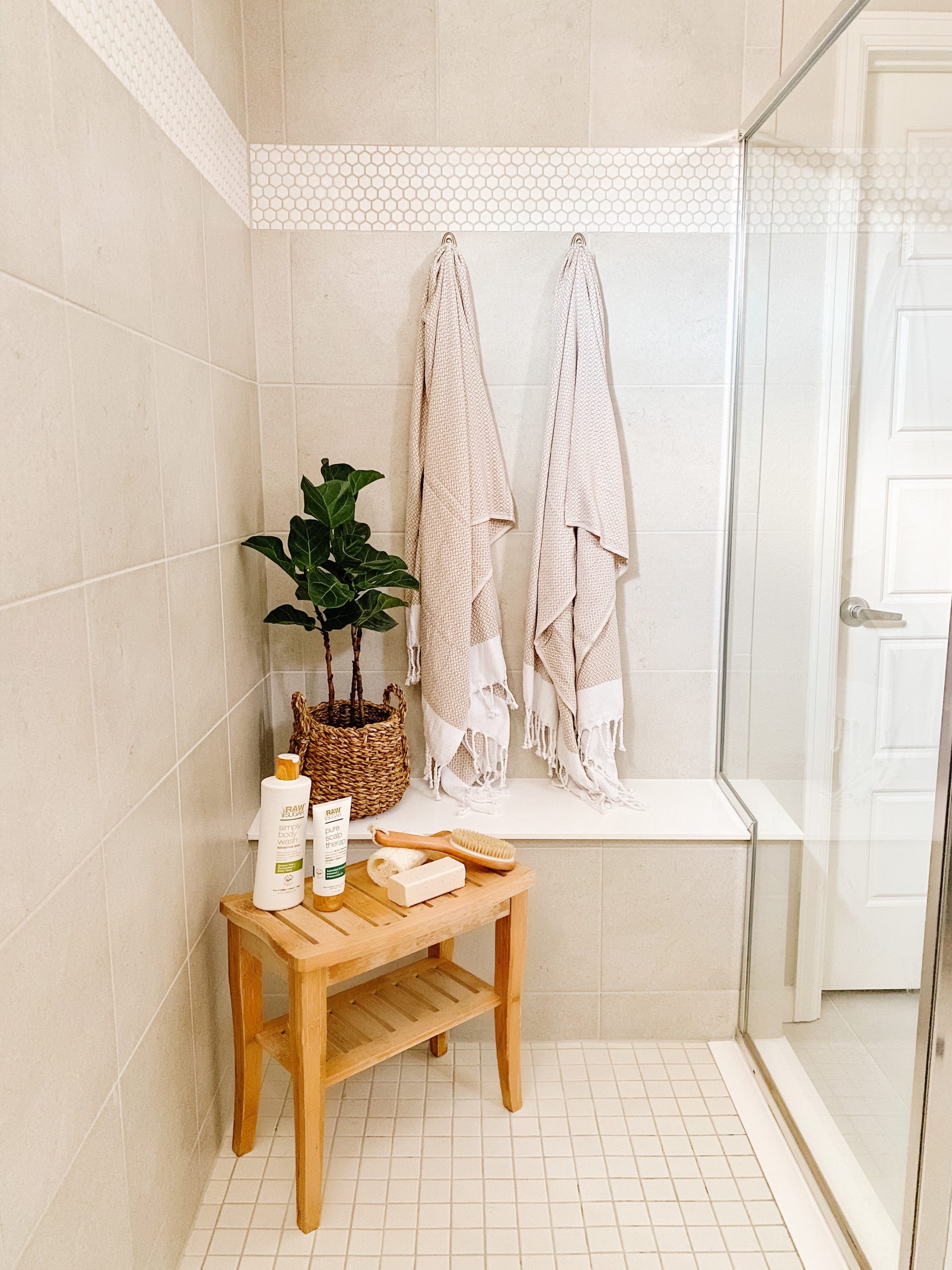 grey tile shower with teak bench and turkish towels