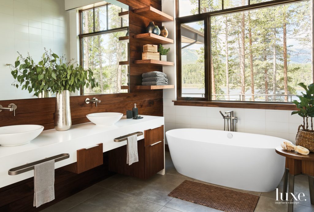 master bathroom with freestanding tub, wood accent wall and white countertops