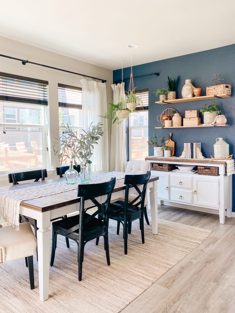 staged home dining room with hale navy accent wall and styled floating shelves