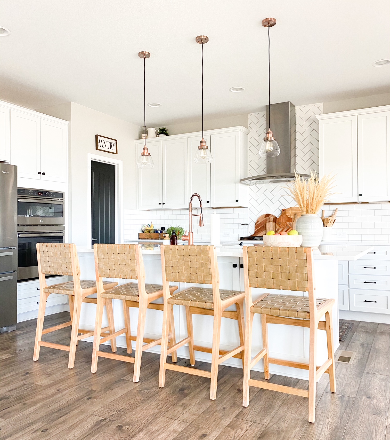 boho bar stools in white kitchen with copper accents 