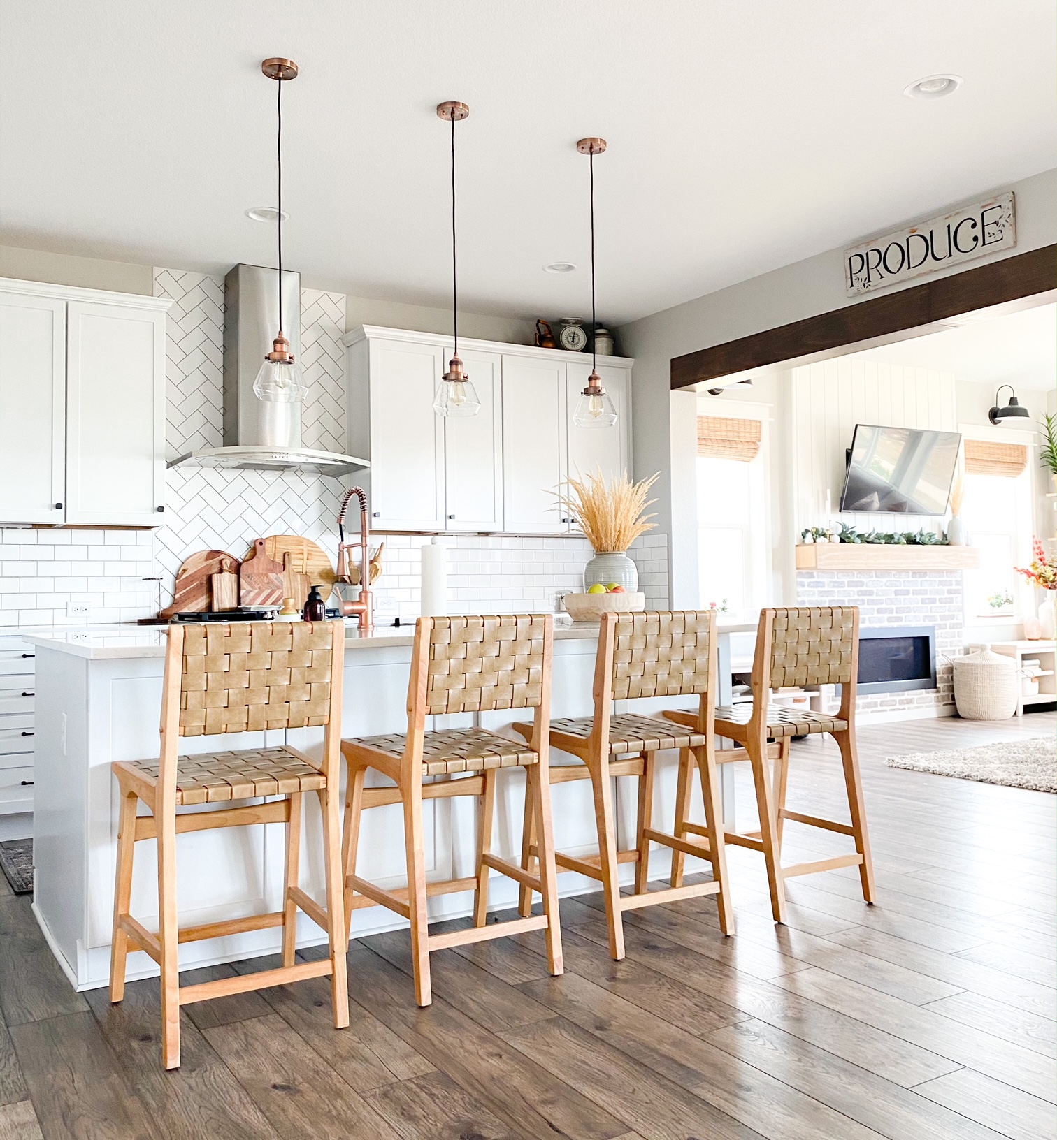 boho bar stools in a white kitchen with  brick and shiplap fireplace in the background