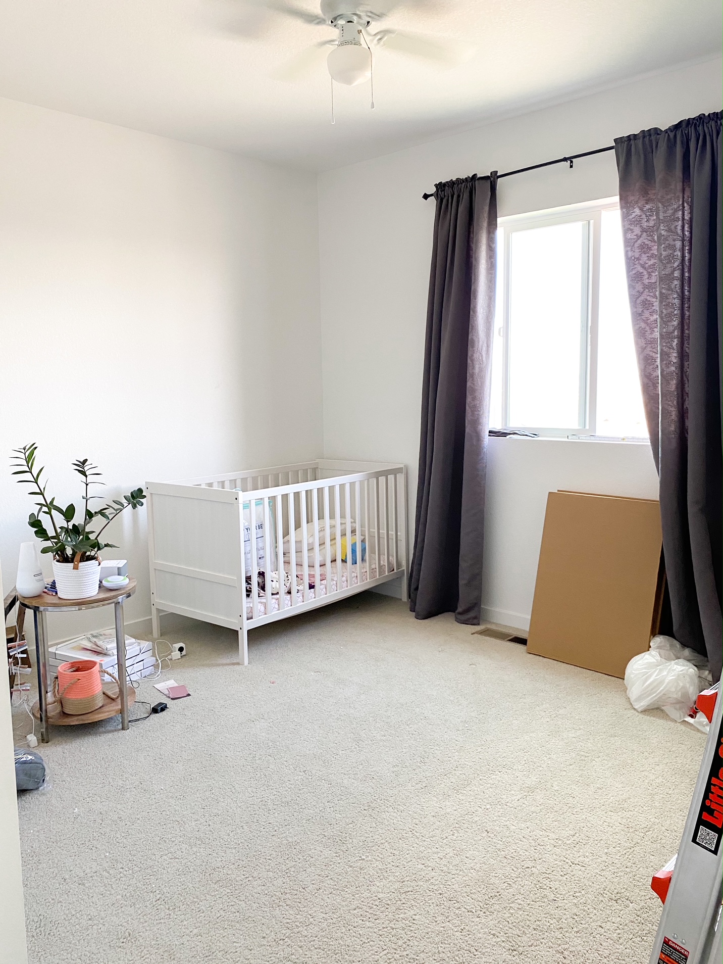 Room with white crib and gray curtains