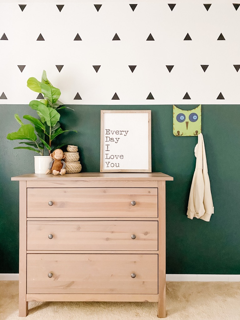 boho toddler room with colorblock dark green and white wall and black triangle wall decals