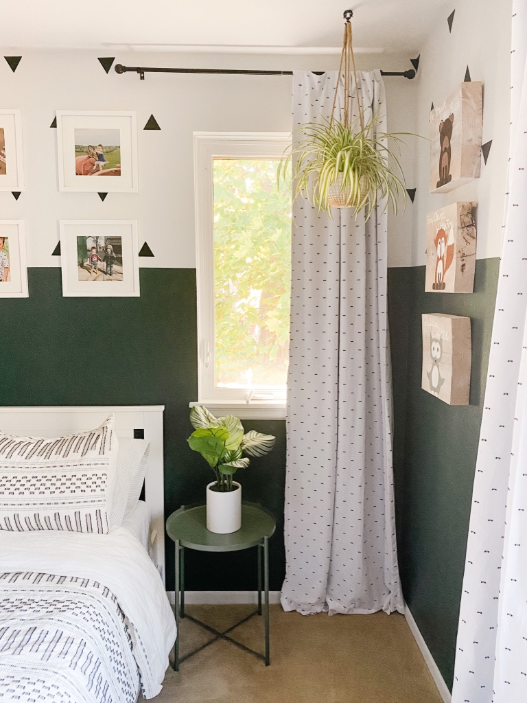 boys boho bedroom idea with colorblock green and white wall and white frame gallery wall