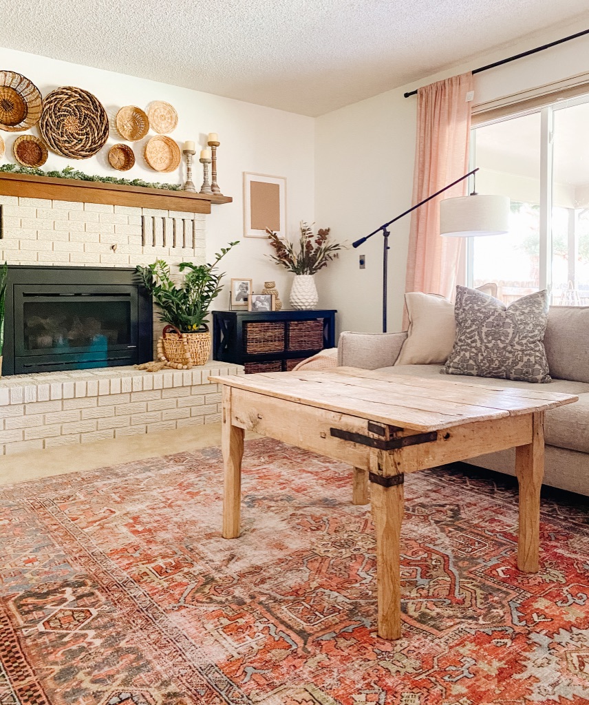 boho living room with brick painted fireplace and boho terracotta area rug from Loloi