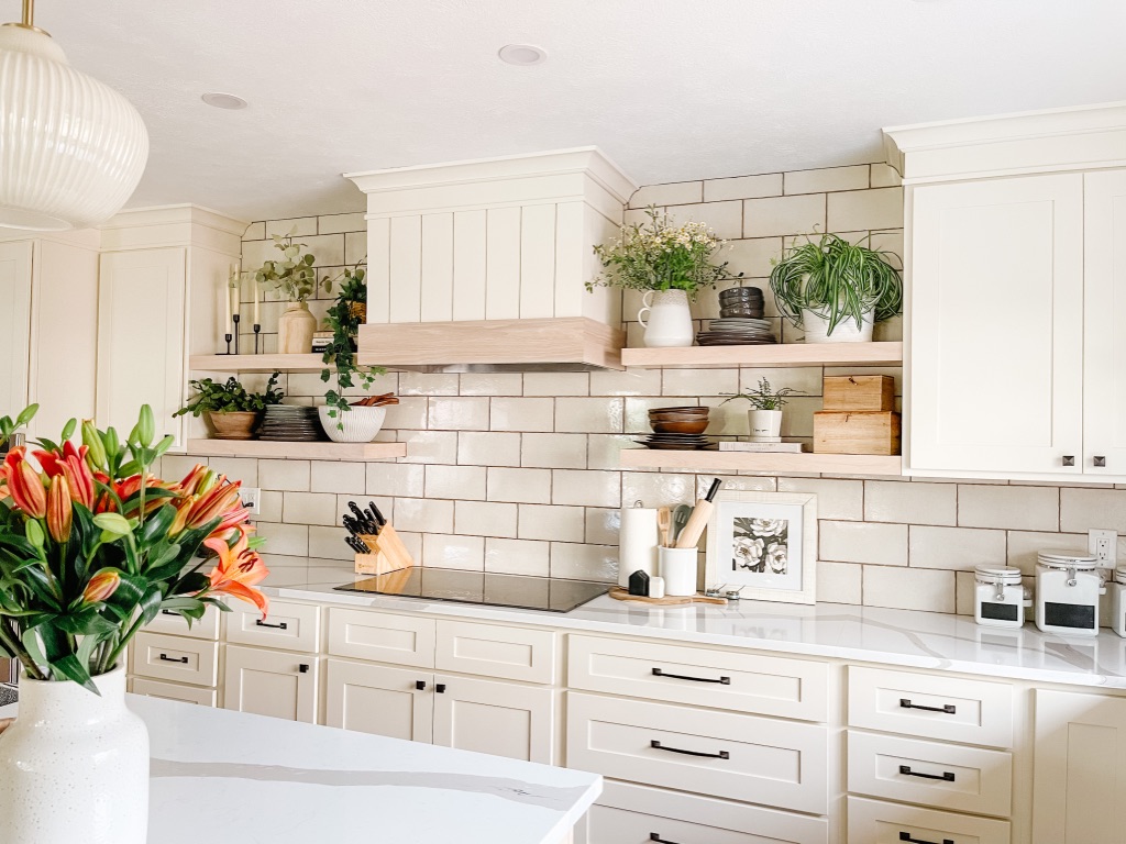 kitchen remodel with beige subway tile backsplash and white oak floating shelves and custom hood cover with shiplap and wood accent