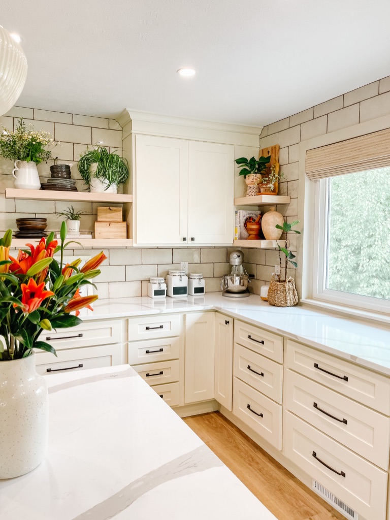 off white kitchen cabinets with white oak opening shelving at the corner and lots of drawers at the lower cabinets