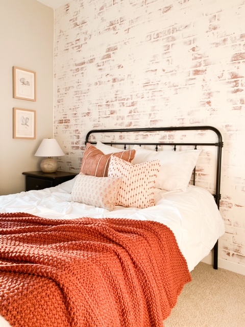 Fall decor in bedroom with white washed brick wall.