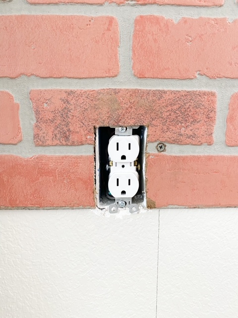 How to cut around the edges of an outlet with a faux brick panel.