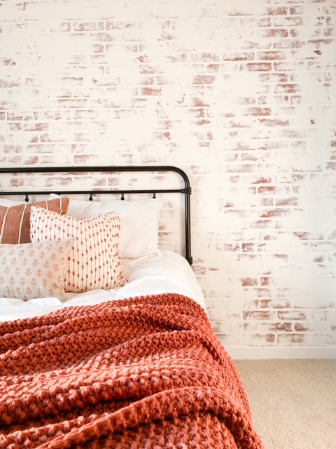 Farmhouse bed with German schmear brick wall.