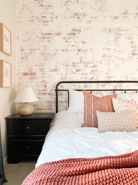 Farmhouse style bedroom with a German schmear brick wall.