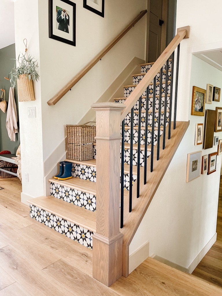 diy peel and stick wallpaper at stair risers with updated stair railing with white oak hand rail and black metal balusters