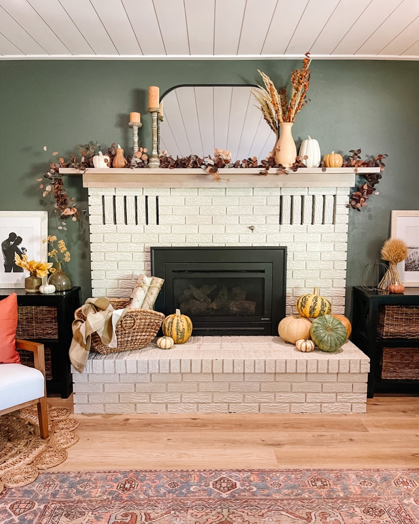 simple fall home decor ideas with moody dark green wall with painted brick fireplace