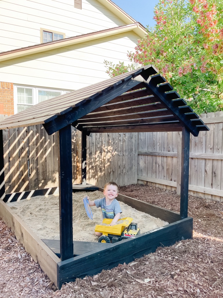 DIY sandbox play house with black wood stain