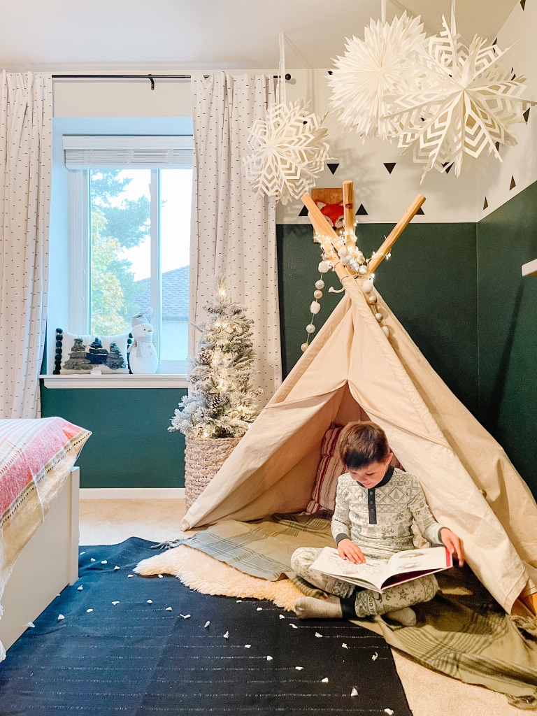 whimsical Christmas teepee reading nook with accent pillows and small flocked Christmas tree
