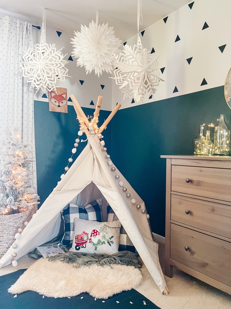 kid's bedroom Christmas decor with whimsical Christmas teepee reading nook with accent pillows and small flocked Christmas tree