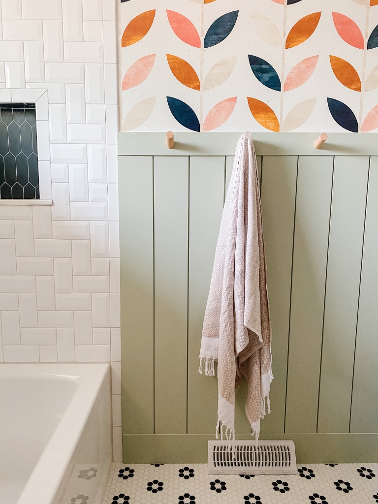 colorful 1970's bathroom remodel with boho scandi peel and stick wallpaper, green vertical shiplap, behr urban nature, and wood peg towel hooks