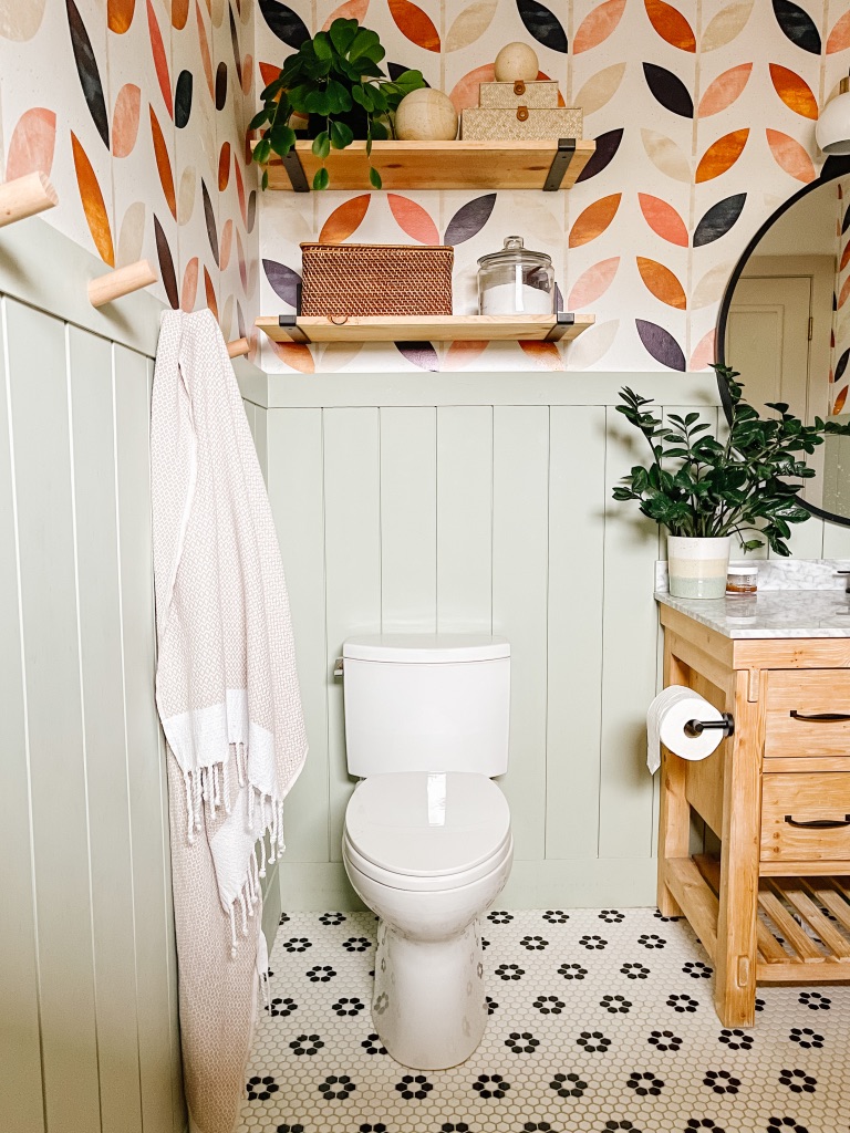 Colorful Boho 1970's Bathroom Remodel with floating wood shelves above toilet and green vertical shiplap - Behr Urban Nature